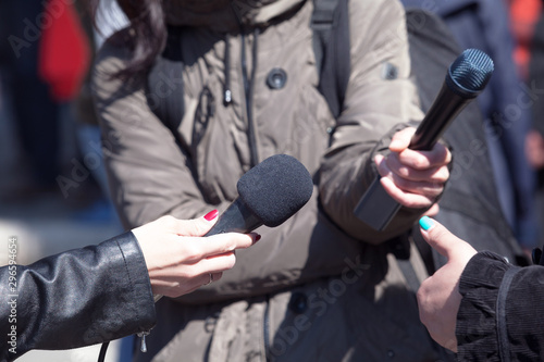 Journalists holding microphones at news conference