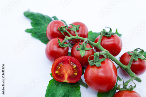 bunch of fresh tomatoes with stem and leaves on white background © Vasin