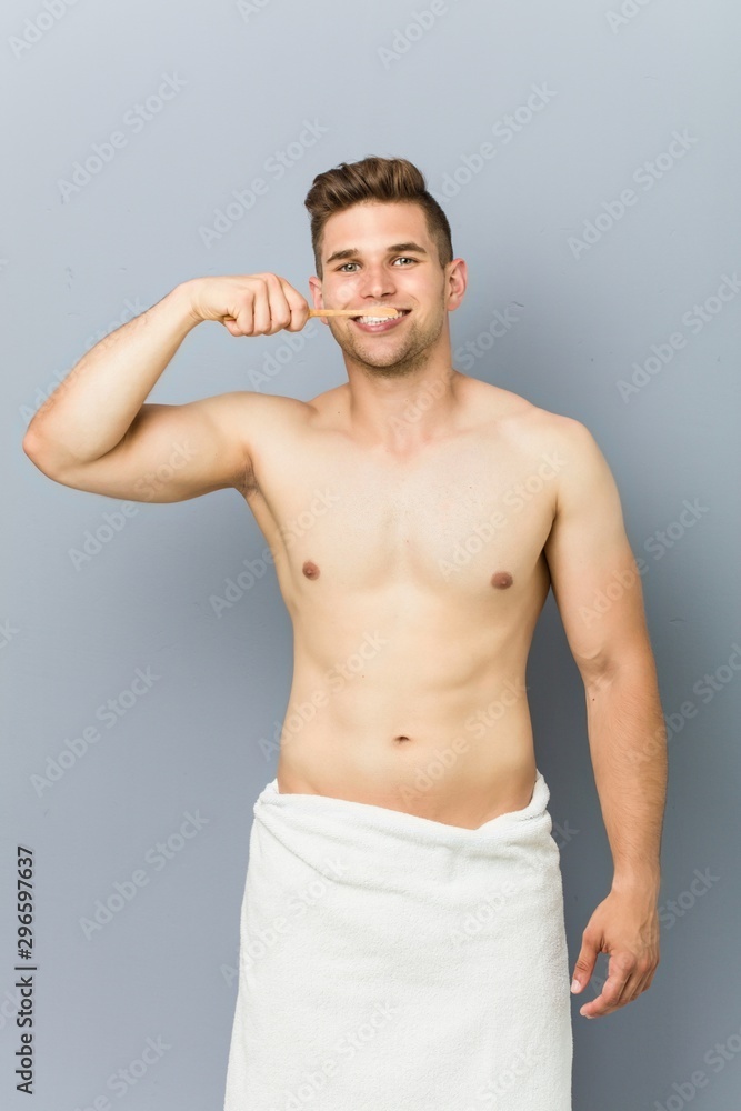 Young shirtless man washing teeth.