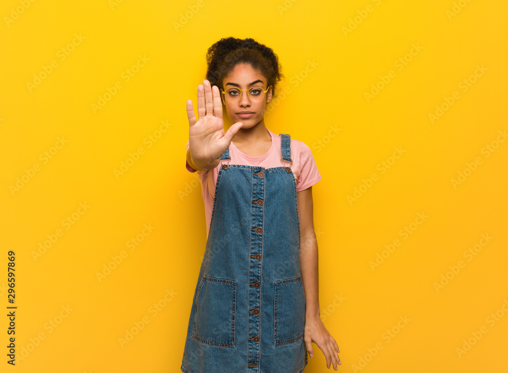 Young black african american girl with blue eyes putting hand in front Young black african american girl with blue eyes putting hand in front