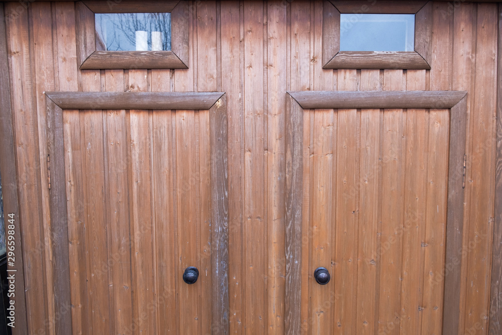 New Toilet and shower made of wood closeup. Garden plot. Glass small Windows. Two wooden doors. Country plot New Toilet and shower made of wood closeup. Garden plot. Glass small Windows. Two wooden doors. Country plot