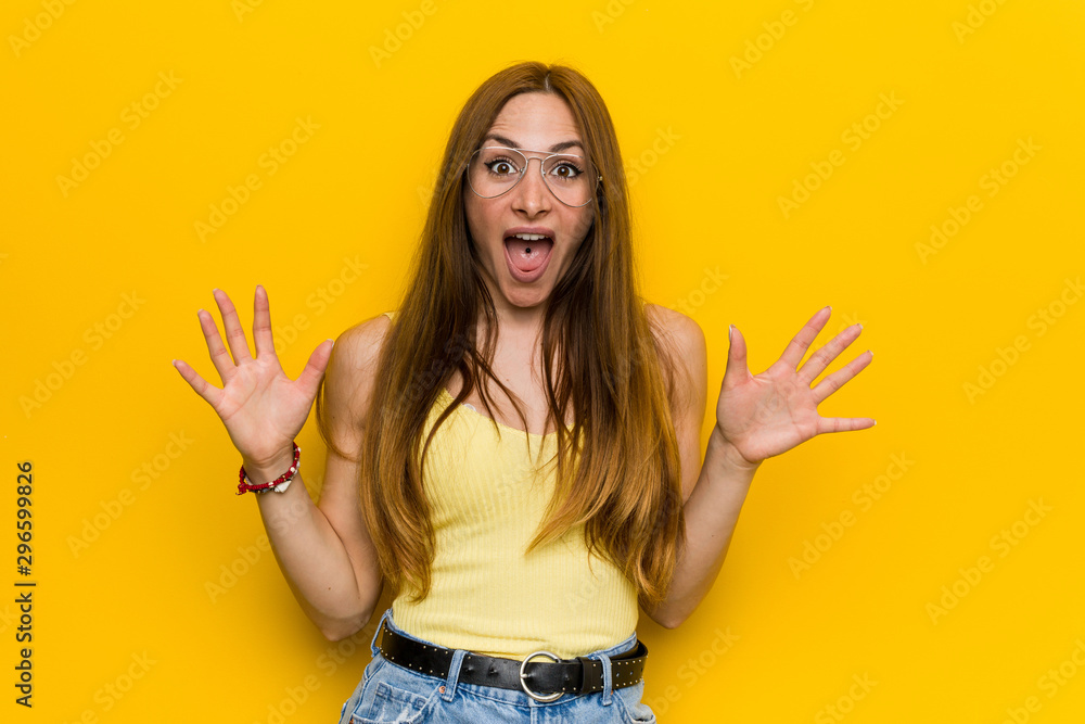 Young redhead ginger woman with freckless celebrating a victory or success, he is surprised and shocked. Young redhead ginger woman with freckless celebrating a victory or success, he is surprised and shocked.