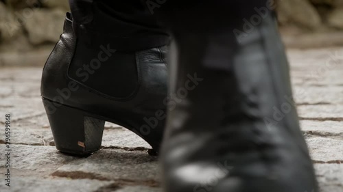 Man and woman dancing flamenco in park. Spanish people and traditional dance in Andalusia, Spain. Dancers performing traditional show in park. Couple and music arts. Detail of male shoes