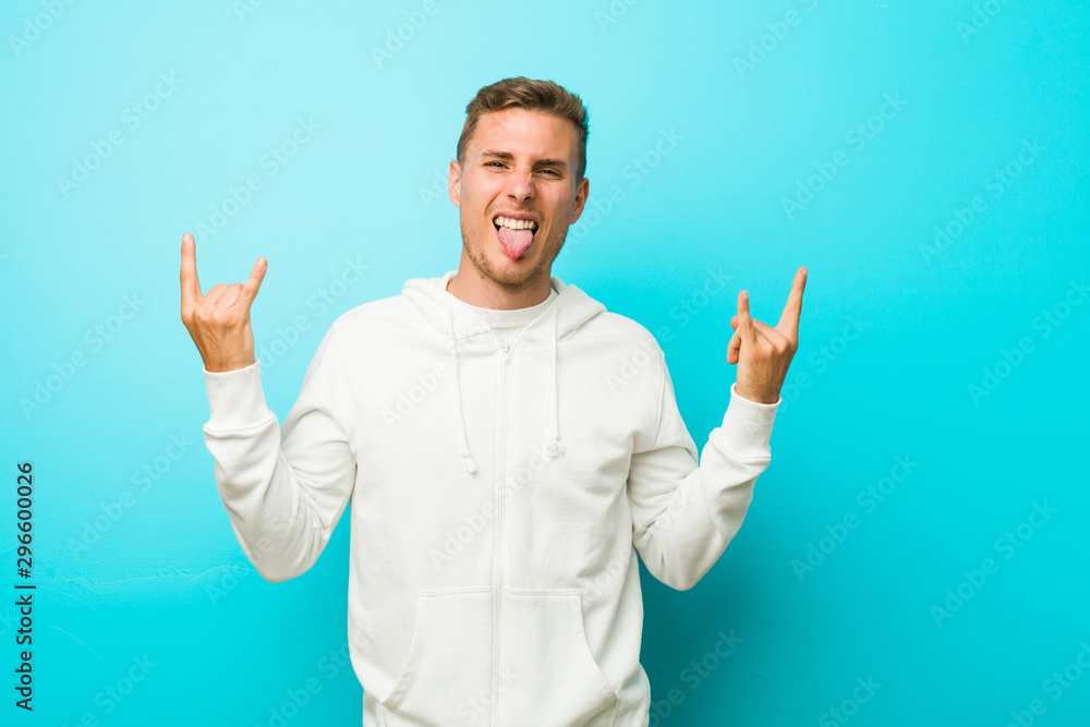 Young caucasian sport man showing rock gesture with fingers Young caucasian sport man showing rock gesture with fingers