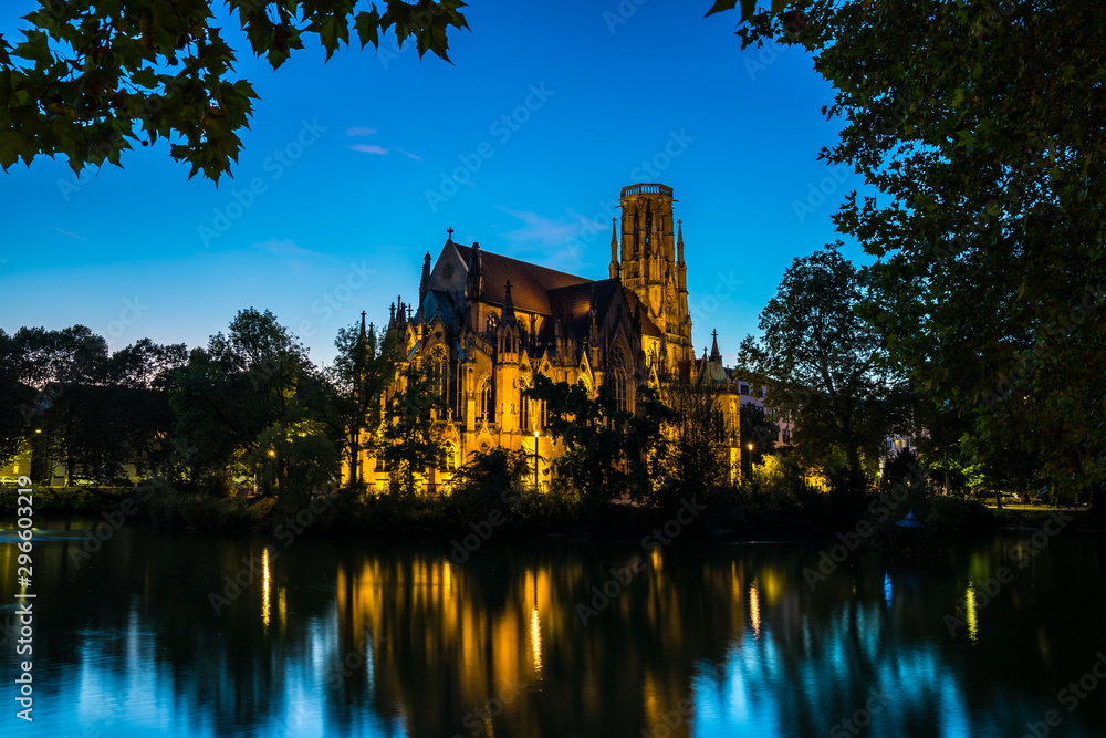 Germany, Famous stuttgart feuersee church building illuminated by night in downtown reflecting in water in magical light by night