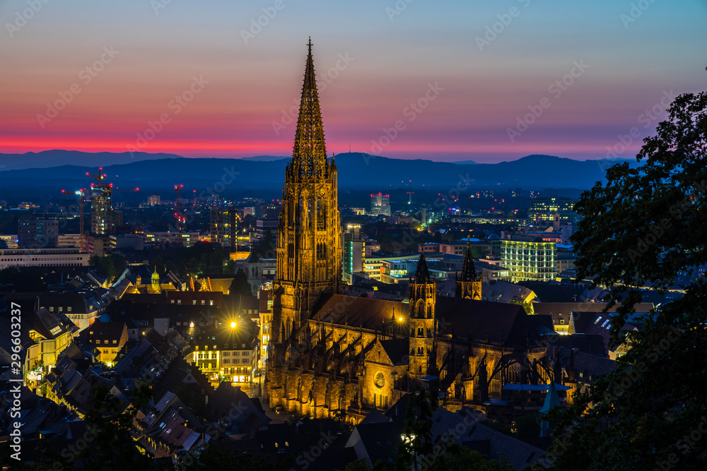 Germany, Romantic red sunset sky over beautiful black forest city freiburg in breisgau in baden with famous gothic cathedral called minster from above
