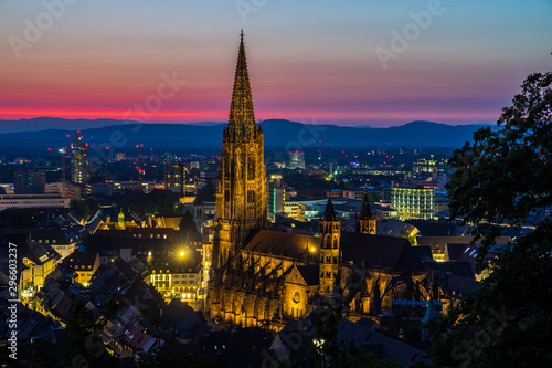 Germany, Romantic red sunset sky over beautiful black forest city freiburg in breisgau in baden with famous gothic cathedral called minster from above