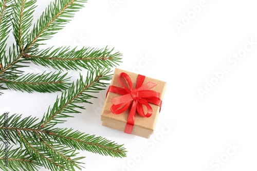 Box with a Christmas present on white background and branch spruce. Top view  copy space.