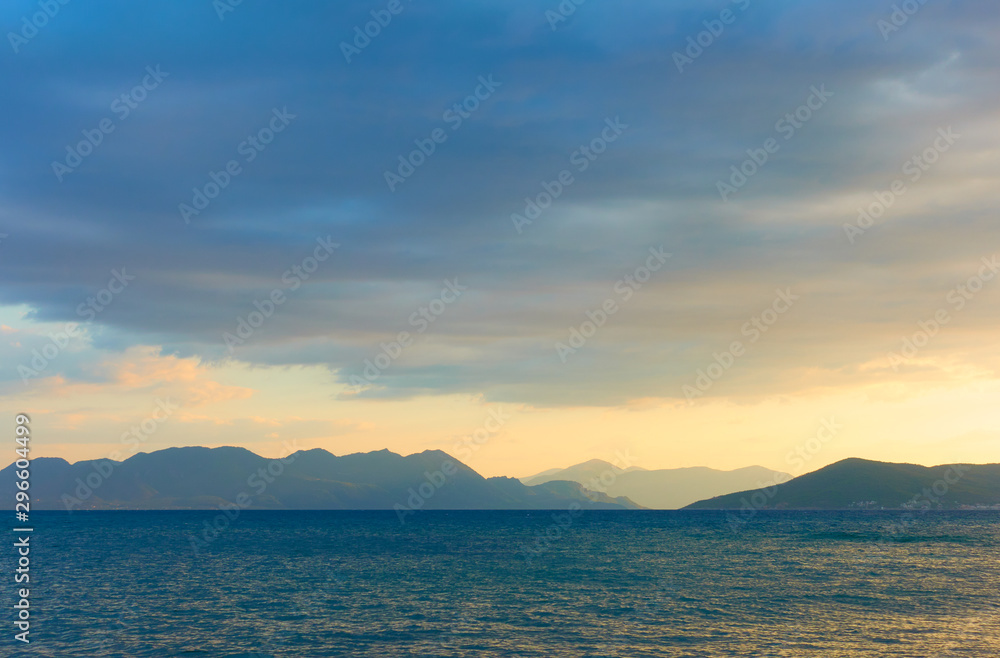 View with the sea, clouds and islands on the horizon at dusk