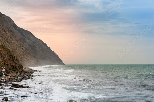 Cliff and sunset light on the sea