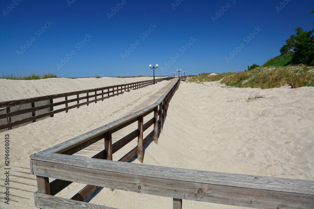 Beautiful scenery of  empty white tropical sand beach. Footprints in the sand. Skyline with the ocean. Deep blue sky without clouds. Summer sunny bright tropical landscape. Coast. Baltic nature