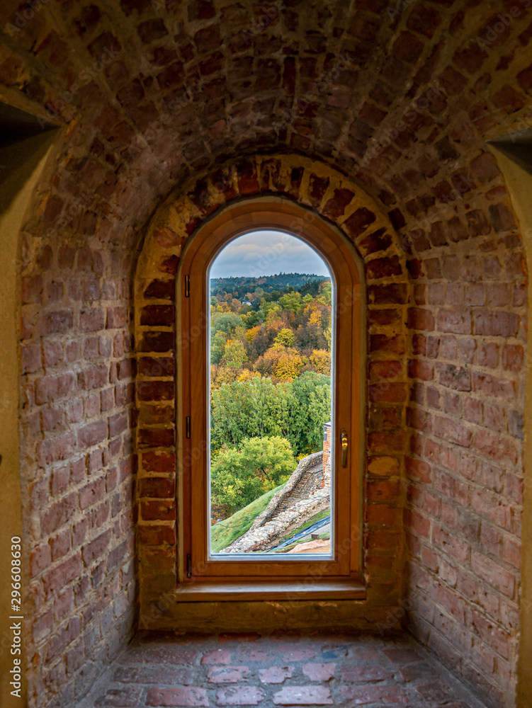 View through a window across fall colored trees in historic Gediminas tower in Vilnius Lithuania