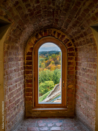 View through a window across fall colored trees in historic Gediminas tower in Vilnius Lithuania