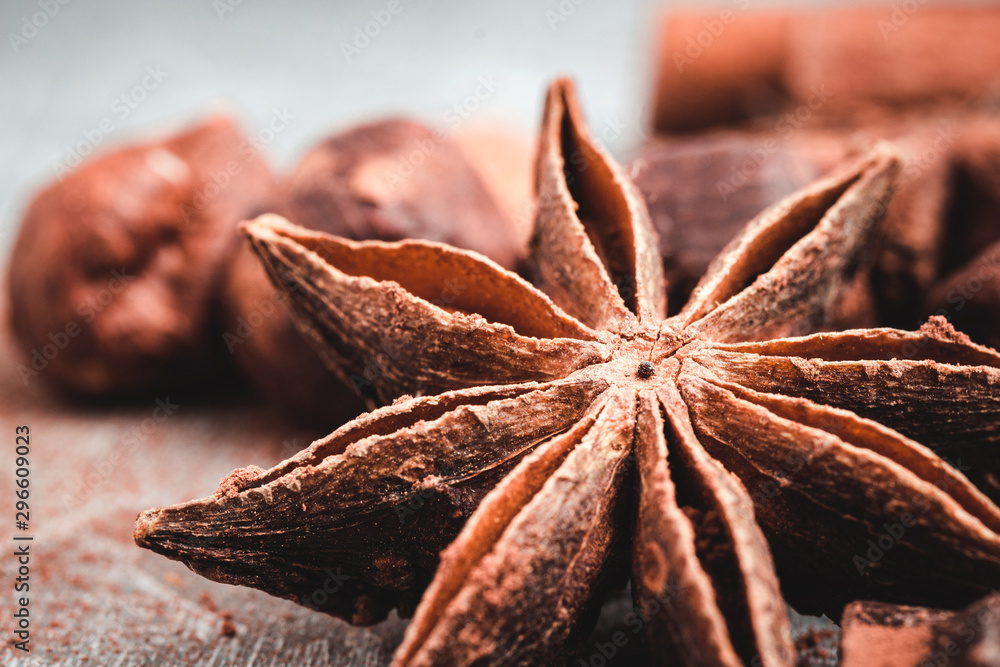 Star anise, chocolate cubes and nuts on grey textured background, close-up view Star anise, chocolate cubes and nuts on grey textured background, close-up view