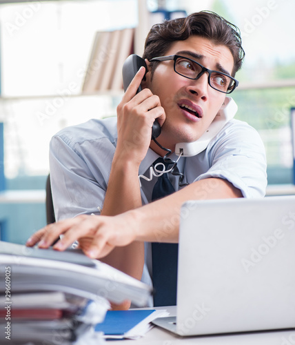 Young businessman under pressure in office to deliver tasks