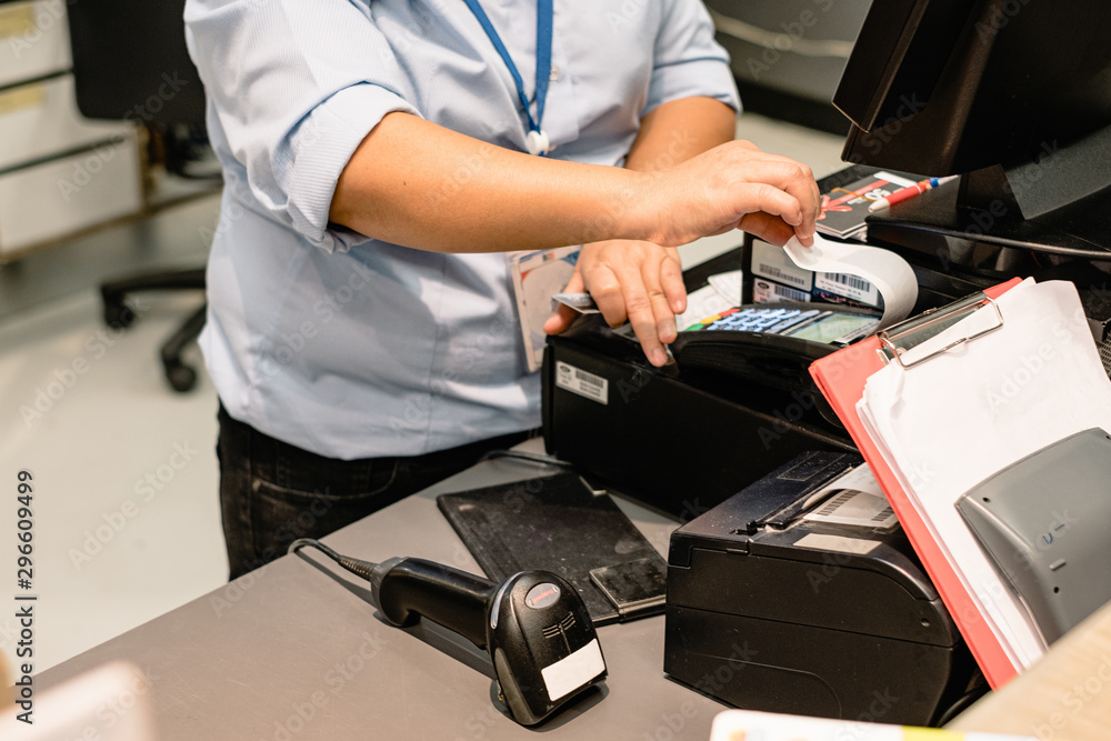 Cashier hand printing and taking receipt from pos terminal. Cashier hand printing and taking receipt from pos terminal.