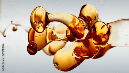 transparent orange gold oil bubbles and fluid shapes in purified water on a white gradient background. Side angle with crystal colored bubbles in purified cosmetic water backdrop with copy space for s