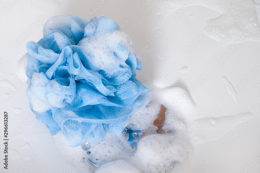 Blue sponge with foam on shower bath floor. Blue sponge with foam on shower bath floor.