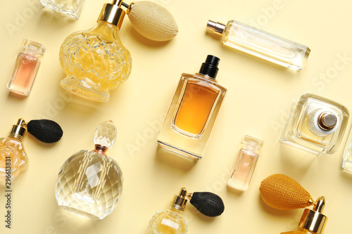 Obraz na plátně Flat lay composition with different perfume bottles on light yellow background