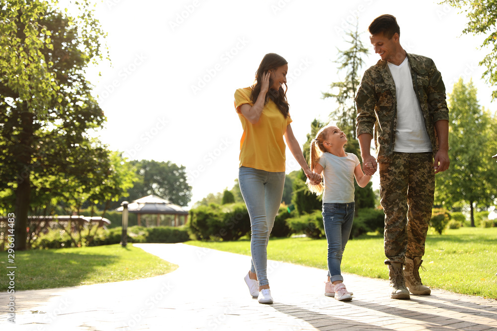 Man in military uniform and his family walking at sunny park Man in military uniform and his family walking at sunny park