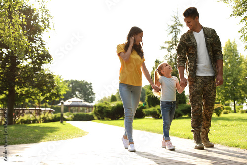 Man in military uniform and his family walking at sunny park