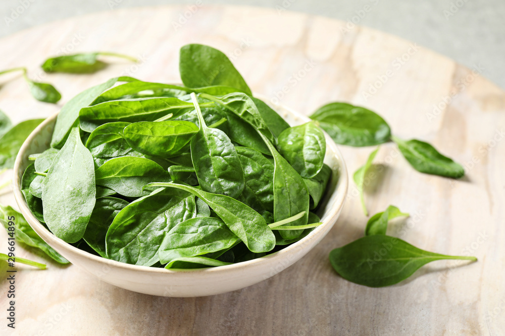 Bowl of fresh green healthy spinach on table Bowl of fresh green healthy spinach on table