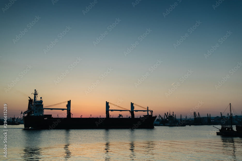 Freight ship in the harbour at sunset