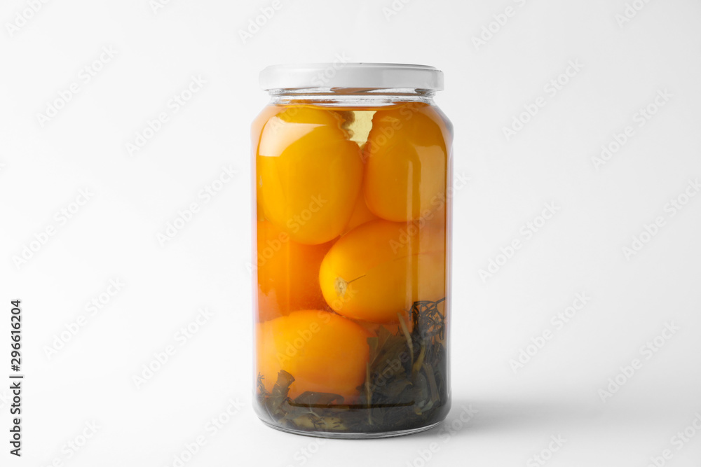 Jar of pickled yellow tomatoes on white background Jar of pickled yellow tomatoes on white background