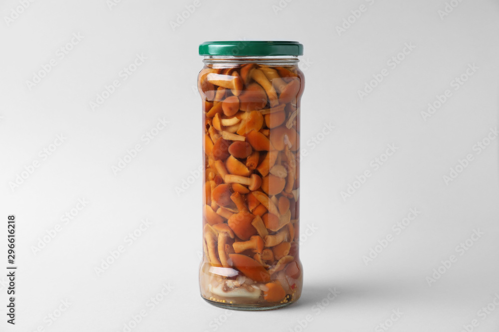 Jar of pickled mushrooms on light grey background Jar of pickled mushrooms on light grey background
