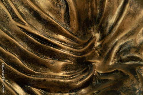 Classic sculpted statue of budhha with wet curtain technique. The clothes appear in folds while revealing the contours of the form below photo