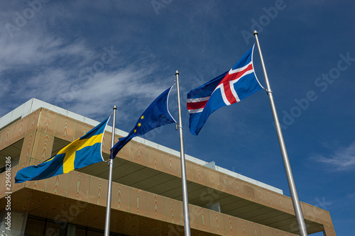 National flags of Sweden, European union and Iceland countries flying in the wind on blue sky background.