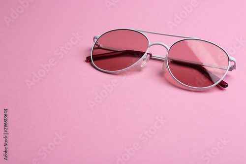 Stylish sunglasses on pink background, space for text. Fashionable accessory