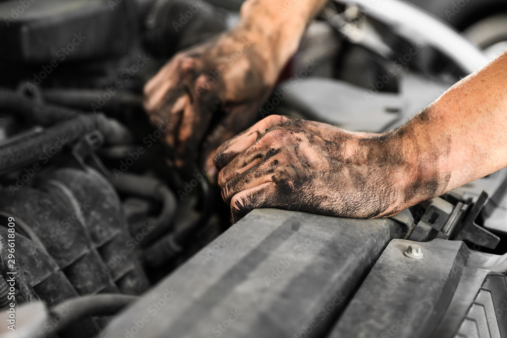 Dirty mechanic fixing car, closeup of hands Dirty mechanic fixing car, closeup of hands