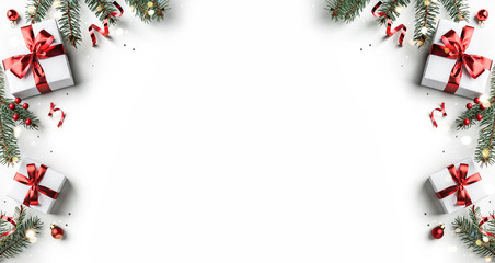Creative frame made of Christmas fir branches, gift boxes, red decoration, sparkles and confetti on white background. Xmas and New Year holiday, bokeh, light. Flat lay, top view
