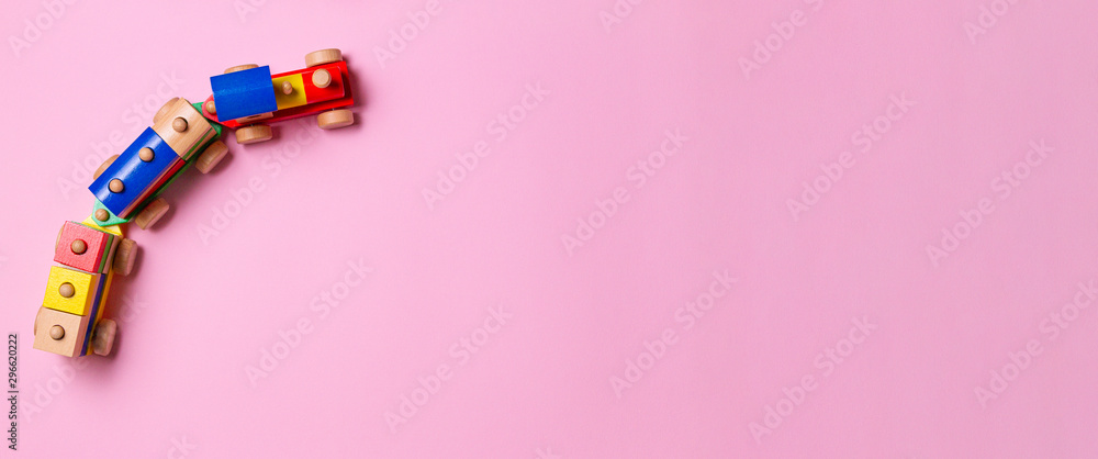 Wooden toy train with colorful blocks on light pink background - obrazy, fototapety, plakaty 