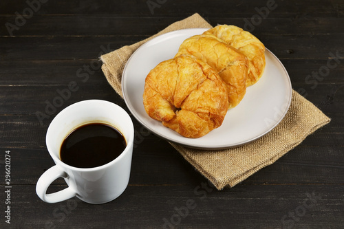 coffee cup and fresh baked croissants on wooden table
