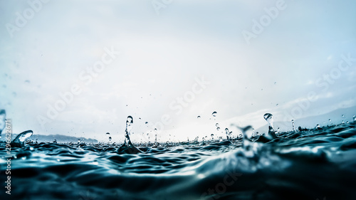 Canvas Print Raindrops splashing into dark blue lake