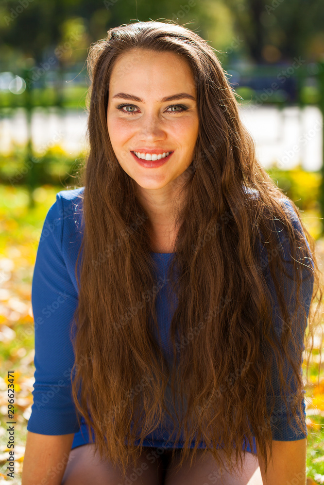 Young beautiful brunette woman in blue dress in autumn park Young beautiful brunette woman in blue dress in autumn park