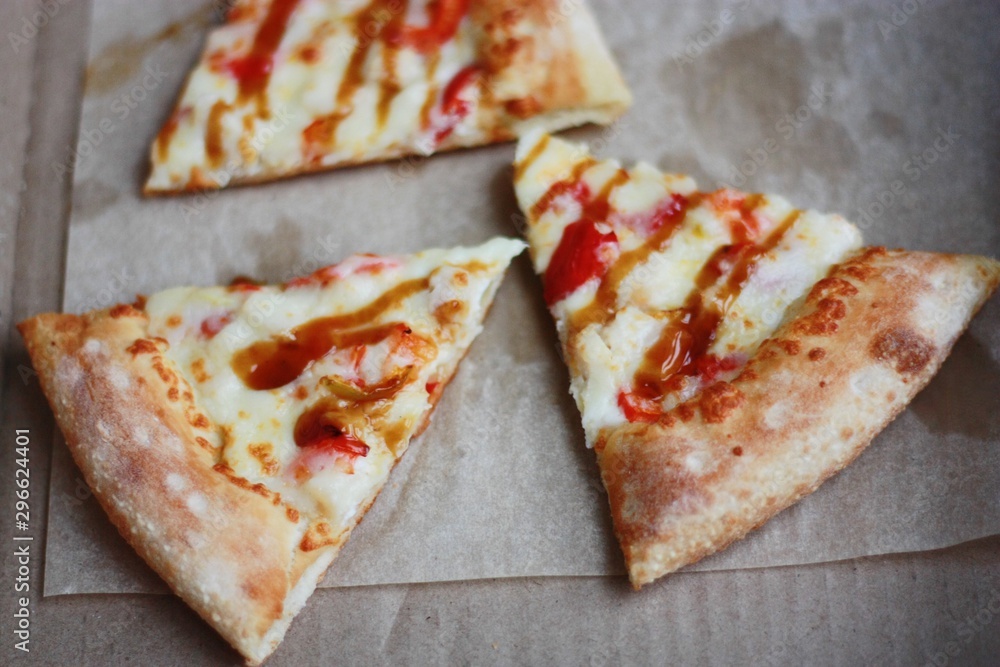 Slices of pizza with cheese on the table Slices of pizza with cheese on the table
