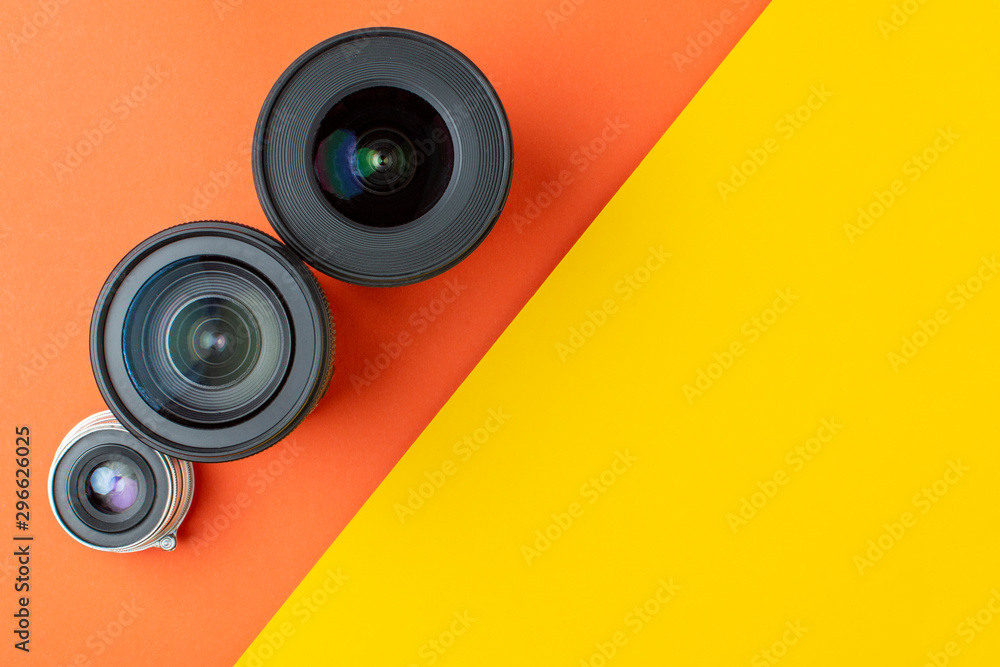 Progress of different photo lenses on a colored background, a set of old and modern photo devices for the camera Progress of different photo lenses on a colored background, a set of old and modern photo devices for the camera