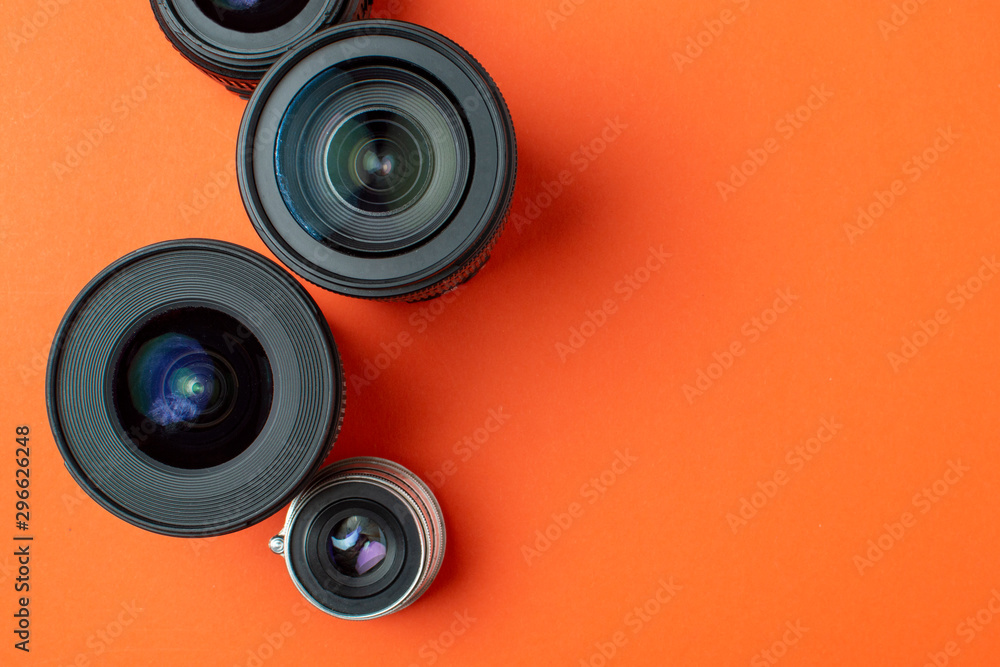 Progress of different photo lenses on a colored background, a set of old and modern photo devices for the camera Progress of different photo lenses on a colored background, a set of old and modern photo devices for the camera