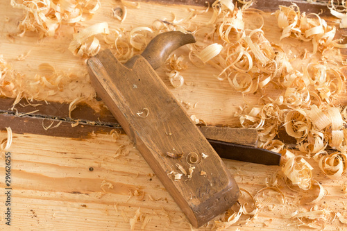 Discarded old wooden hand plane for woodworking with wood shavings.