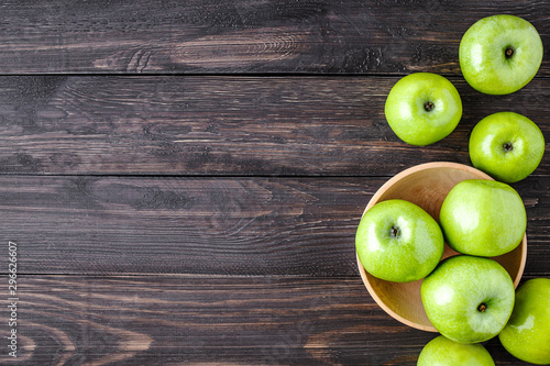 Ripe green apples and apple slices on old wooden background.Vegetables for diet and healthy eating.Organic food. Place for text. Top view