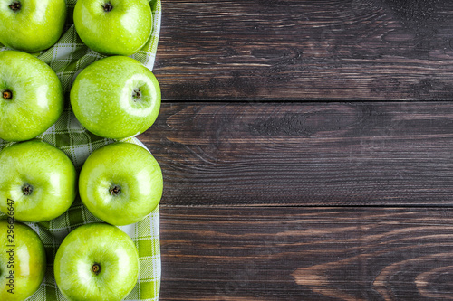 Ripe green apples and apple slices on old wooden background.Vegetables for diet and healthy eating.Organic food. Place for text. Top view