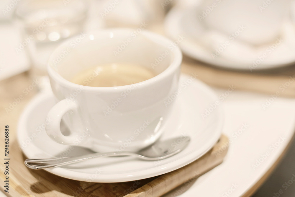 Coffee in a white cup on the table in a cafe. Selective DOF. Coffee shop blurred background. Coffee in a white cup on the table in a cafe. Selective DOF. Coffee shop blurred background.