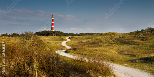 Path leading through the dunes towards vuurtoren, lighthouse of Ameland photo
