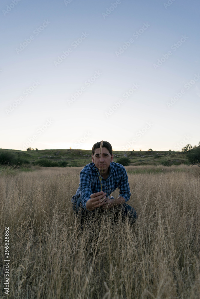 Man crouched in natural environment at a sunny afternoon Man crouched in natural environment at a sunny afternoon