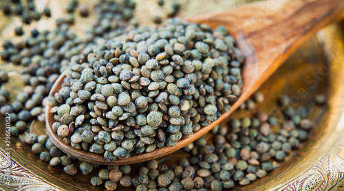 Puy Lentils -  French Green legume, dried grains on wooden spoon. photo