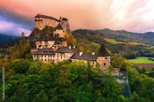 Orava castle - Oravsky Hrad in Oravsky Podzamok in Slovakia. Medieval stronghold on extremely high and steep cliff by the Orava river. Aerial view in sunrise light in autumn