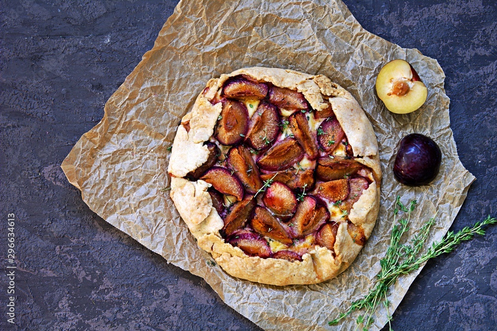 Unsweetened shortcrust pastry pie with plums, brie cheese and thyme. Top view. Plum recipies. Unsweetened shortcrust pastry pie with plums, brie cheese and thyme. Top view. Plum recipies.